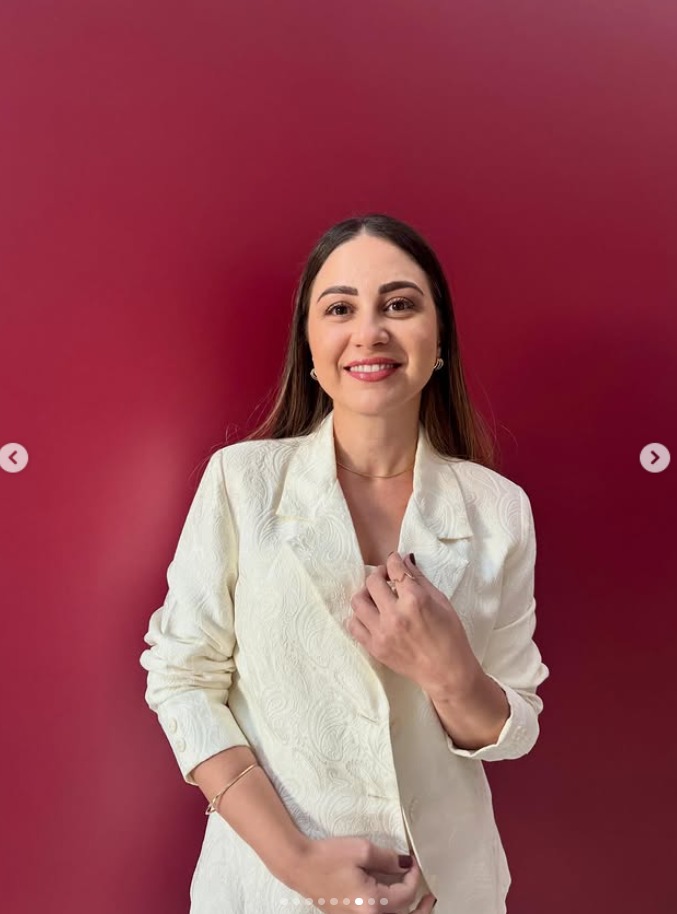 Retrato de Fernanda Cunha, terno branco, fundo vermelho